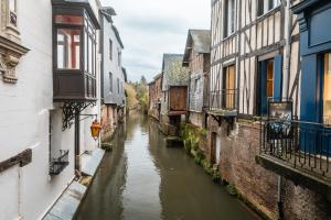 a narrow canal between two buildings in a city at Murmures de la Risle in Pont-Audemer