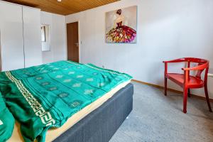 a bedroom with a bed and a red chair at Eule in Donaueschingen