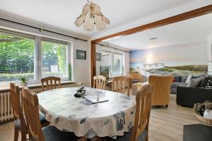 a dining room and living room with a table and chairs at Haus Gerda in Stadum