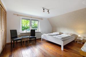 a bedroom with a bed and a table and chairs at Haus Gerda in Stadum