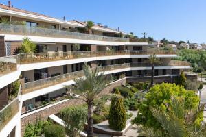 an apartment building with a courtyard with palm trees at Appartement T2 Muses in Le Crès