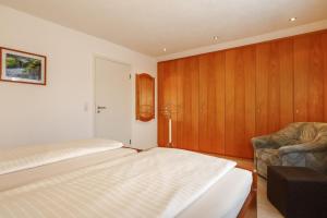 a bedroom with a bed and a chair in it at Ferienwohnung Irmi in Hergensweiler