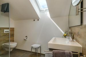 a bathroom with a sink and a toilet and a window at Ferienwohnung Irmi in Hergensweiler