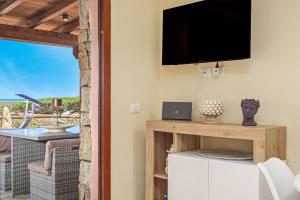 a living room with a flat screen tv on a wall at Villa Caterina in Punta Molara