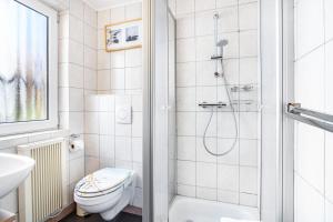 a bathroom with a shower and a toilet and a sink at Ferienhaus Lütt-Matten in Ostseebad Sellin +23 photos