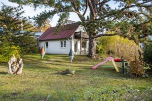 a house with a playground in the yard at Ferienhaus Lütt-Matten in Ostseebad Sellin