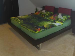 a bedroom with a bed with a green comforter at Ferienhaus Kudensee in Kudensee