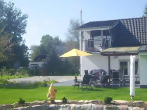 a yellow fire hydrant in front of a house at Ferienhaus Kudensee in Kudensee