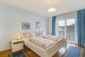 a white bedroom with a bed and a window at Ferienwohnung Wennesz 1 in Chieming