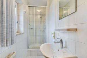 a white bathroom with a sink and a shower at Ferienwohnung Wennesz 1 in Chieming