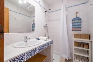 a white bathroom with a sink and a mirror at Soller beach apartment in Sóller
