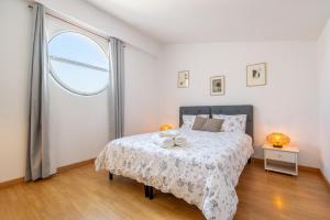 a bedroom with a bed and a large window at Soller beach apartment in Sóller