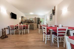 a restaurant with red and white tables and chairs at Nonno Bigi Rosa in Tremosine Sul Garda +22 photos