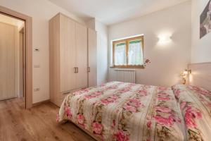 a bedroom with a bed with a floral bedspread at Nonno Bigi Rosa in Tremosine Sul Garda