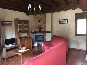 a living room with a red couch and a fireplace at Los Avellanos Casa 2 in Celis +21 photos