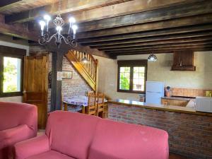 a living room with a pink couch and a kitchen at Los Avellanos Casa 2 in Celis