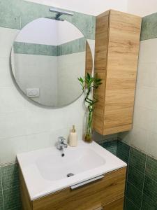 a bathroom with a white sink and a mirror at Il Rifugio di Palmanova in Palmanova