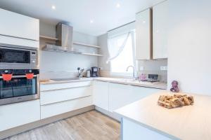 a kitchen with white cabinets and a counter top at Maison de vacances proche de tout in Quimper +14 photos
