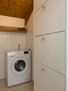a laundry room with a washing machine and cabinets at Il Rifugio di Palmanova in Palmanova +3 photos