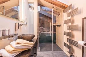 a bathroom with a sink and a glass shower at Paruda Mountainchalet in Ortisei +22 photos