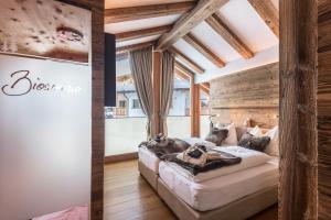 a bedroom with a large bed in a room with wooden walls at Paruda Mountainchalet in Ortisei