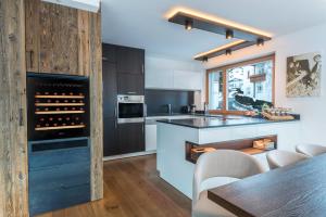 a kitchen with a wine cellar with a table and chairs at Paruda Mountainchalet in Ortisei
