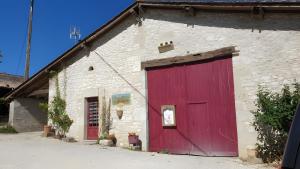 a red door on the side of a stone building at Le Gite Du Vigneron Périgord in Razac-de-Saussignac +7 photos