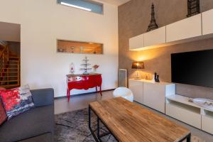 a living room with a couch and a table at Le Loft avec jacuzzi in Saint-Gildas-de-Rhuys