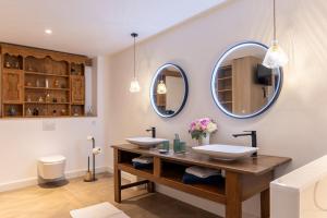 a bathroom with two sinks and two mirrors at Le Loft avec jacuzzi in Saint-Gildas-de-Rhuys +26 photos