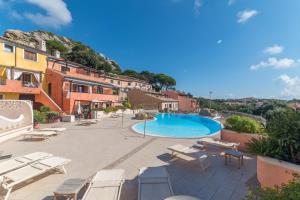 a resort with a pool and chairs and buildings at C 102 Puntavilla Mare in La Maddalena
