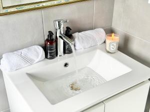 a bathroom sink with water running from a faucet at Résidence Gaïa - Etretat in Étretat +45 photos
