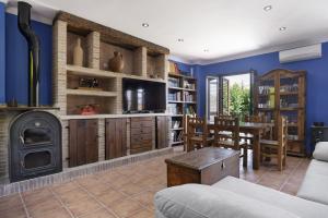 a living room with a fireplace and blue walls at Casa Las Niñas in Olvera