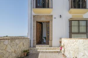 a door to a building with a stone wall at Casa Las Niñas in Olvera