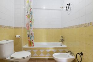 a bathroom with a tub and a toilet and a sink at Casa Las Niñas in Olvera +18 photos