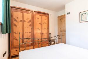 a bedroom with a bed and a wooden cabinet at Maso Noce Est in Mezzana