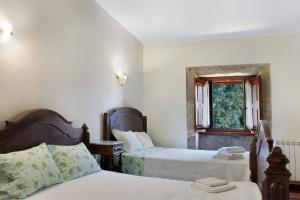 a bedroom with two beds and a window at Quinta Da Ataíde in Rendufe +37 photos