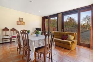 a dining room with a table and a couch at Quinta Da Ataíde in Rendufe