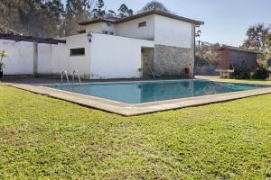 a swimming pool in front of a house at Quinta Da Ataíde in Rendufe