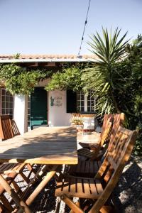 a wooden table and chairs in front of a house at Casa do Vagar in Vimieiro
