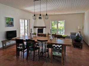a dining room with a wooden table and chairs at Casa do Vagar in Vimieiro