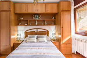 a bedroom with a bed with wooden cabinets and a window at Mila Somo in Somo