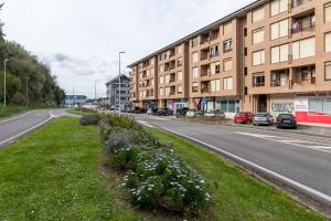 an empty street with buildings and flowers on the side at Mila Somo in Somo