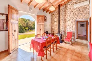 a dining room with a table and a large window at Finca Sa Pova in Alcudia