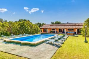a pool with lounge chairs and a house at Finca Sa Pova in Alcudia