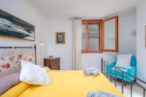 a bedroom with a yellow bed and a blue chair at 5 Appartamento Isuledda in San Teodoro +17 photos