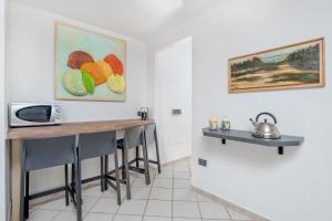 a kitchen with a table with chairs and a microwave at 5 Appartamento Isuledda in San Teodoro