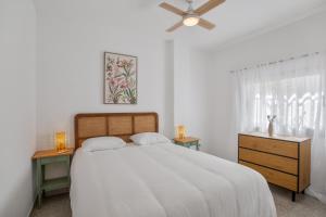 a white bedroom with a bed and a ceiling fan at Apartamento Danoe 5 in Mogán
