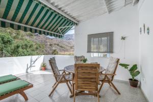 a dining room with a table and chairs on a balcony at Apartamento Danoe 5 in Mogán