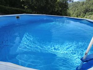 a large pool of blue water with a pole in it at Quintinha Da Aldida - Gerês in Vieira do Minho