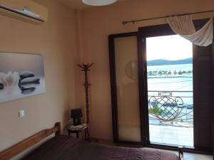 ein Schlafzimmer mit großer Glasschiebetür zum Balkon in der Unterkunft Pylos before midnight in Pylos